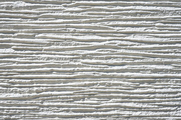 close-up white concrete wall texture background, cement walls are decorated with plastering techniques to have rough surface. Decoration exterior facade building wall