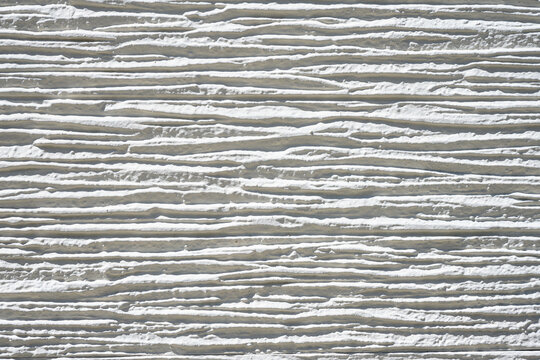 close-up white concrete wall texture background, cement walls are decorated with plastering techniques to have rough surface. Decoration exterior facade building wall