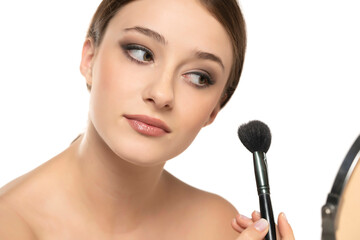 Woman using make-up brush, isolated on white background