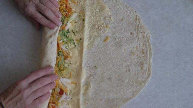 Cooking Burritos, Mexican Food At Home. Fried Wheat Tortilla Stuffed With Cheese, Chicken, Lettuce, Tomato And Sauce. Delicious Burrito Tortilla Wrapping