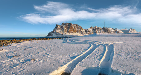 Fabulous winter scenery on Uttakleiv beach at morning with car tracks