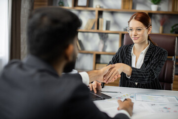 Happy caucasian male job seeker shake hand of smiling female hr manager being accepted on vacant place. Diverse business partners handshake close deal come to agreement. Greetings, you are hired.