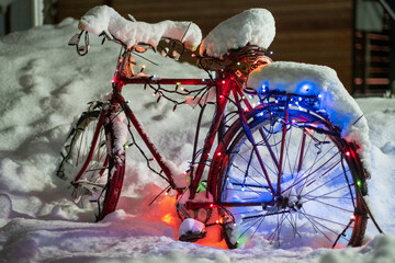 Bike in the snow on the street. The bike is decorated for the New Year