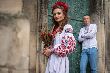 Portrait of a happy young couple in love, a family walking in the old city of Lviv in traditional Ukrainian shirts, walking holding hands. Young people hug in the old town of Lviv