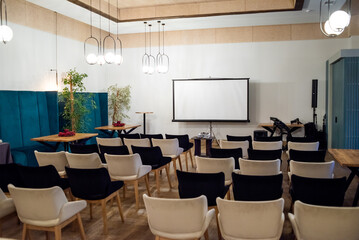 Meeting conference room with blank empty mockup screen for advertising standing in modern contemporary office on wall background. No people. Business technologies concept.
