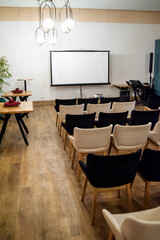 Meeting conference room with blank empty mockup screen for advertising standing in modern contemporary office on wall background. No people. Business technologies concept.