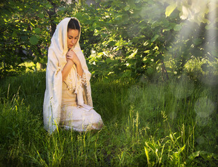 Praying woman in ancient light clothes