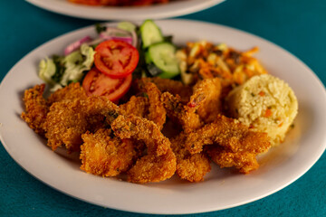  Plato de camarones empanizados con aderezo, ensalada, arroz y salsas.