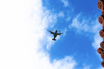 沖縄赤瓦と上空を飛行する軍用機