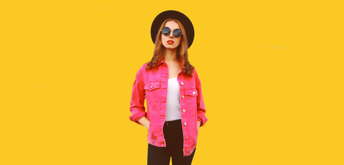 Portrait of stylish modern young woman wearing pink jacket, black round hat on white background, blank copy space for advertising text