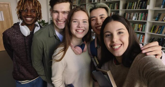 Happy friendly smiling multi ethnic students posing for camera, make picture, gesturing, recording video for vlog staring at cam. Friendship, education, generation Z using modern wireless technology