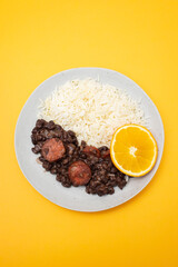 Typical brazilian food beans with sausages and rice Feijoada on white dish