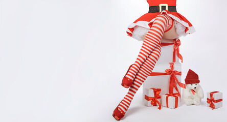 Sexy Santa Claus woman legs and christmas gifts. Beautiful sexy woman in Santa costume with long legs in striped stockings and red heels.
