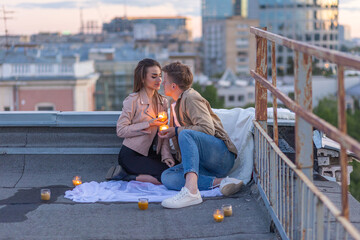 Beautiful young loving couple on a surprise date on a Saint Valentine's Day on a rooftop. Romantic...