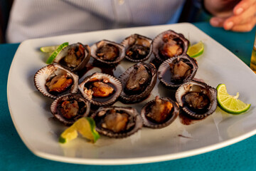 Plato de ostiones servidos con salsa inglesa en un plato blanco