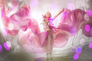 Portrait of cute kid girl posing in pink beautiful dress on a white background. Model in studio looking as gentle magic princess from fairy taly