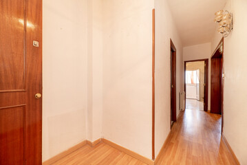 Lobby of a house with a solid wood access door, laminated flooring and sconces with crystal lampshades