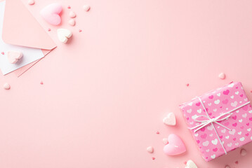 Saint Valentine's Day concept. Top view photo of giftbox envelope with paper sheet heart shaped marshmallow candles and sprinkles on isolated light pink background with copyspace