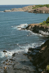 Fototapeta na wymiar Cliff rocks on a sandy beach shore summer landscape in Costa Brava, Catalonia