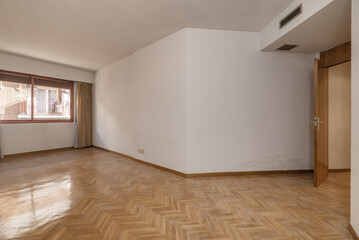 Fototapeta na wymiar Empty room with white painted walls, French oak parquet wooden floor placed in a herringbone pattern with matching doors and skirting boards, red anodized aluminum windows