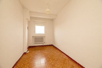 An empty room with eggshell white painted walls with orange vintage tile flooring and a ceiling lamp