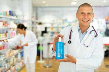 Positive male pharmacist offers various body care medicines