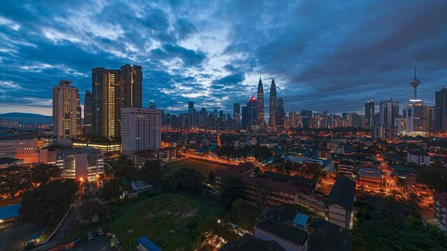 High Angle Time lapse view of  busy city streets and golden sunrise against a skyline in Kuala Lumpur, Malaysia. Tilt up motion timelapse. Prores 4KUHD.