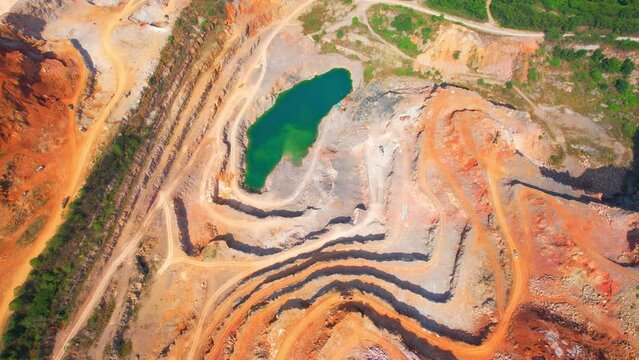 Drones are flying over a large quarry, many machines are working. stone industry. stone is a important construction material used to build infrastructure. The problem of dust, smoke and pollution.
