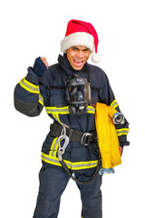 Exited young African American fireman in uniform and red Santa Hat holds fire hose in hand and looking at camera isolated on white background, vertical orientation 