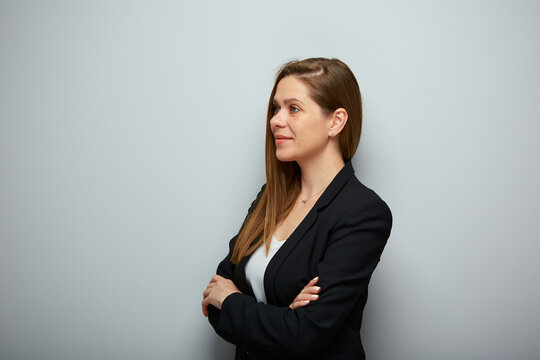 Smiling business woman in black suit looking away, isolated profile portrait.