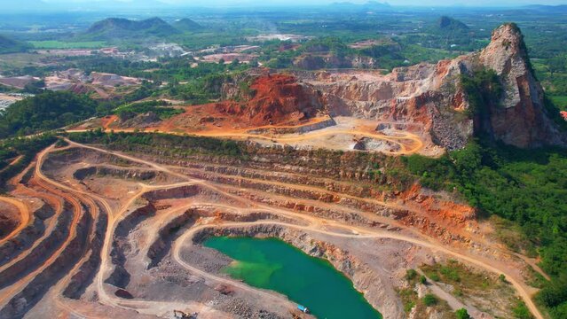 Drones are flying over a large quarry, many machines are working. stone industry. stone is a important construction material used to build infrastructure. The problem of dust, smoke and pollution.
