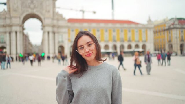 Caucasian brunette Woman in eyeglasses standing city street. Smiling Adult Elegant Lady stand outdoors. Stylish person in glasses middle shoot teeth gummy smile. Commerce square in lisbon 
