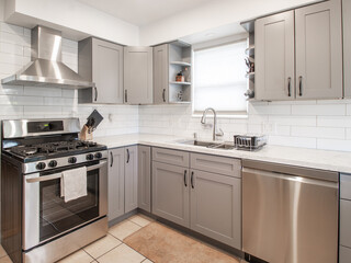 A beautiful small modern kitchen with grey cabinets in Luxury Home with Stainless Steel stock photo
