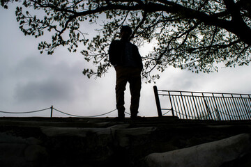 silhouette of person walking on bridge