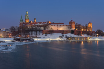 Fototapeta na wymiar Krakow snowy winter, evening Wawel Castle over Vistula river, Poland