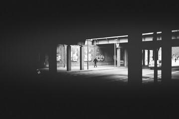 Urban Bridge, tunnel in a city, a man walking by, graffiti on the walls, lights and shadows creating an mystical atmosphere 