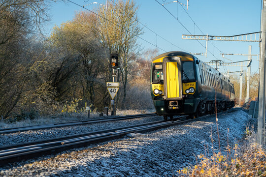 An electric commuter train on a frozen frosty icy track travelling to London Paddington on the GWR near Reading, United Kingdom - December 2022