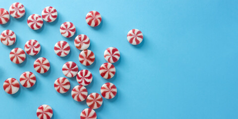 Close-up striped caramel candies on blue background. Christmas banner for candy shop. Selective focus, copy space.