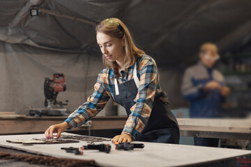 Small family team business woman working as carpenter in workshop carpentry