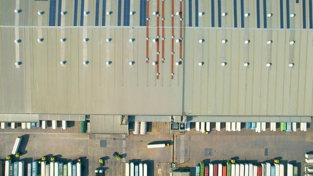 Aerial view from drone above a outdoor distribution warehouse, logistics park areas, containers for shipping with semi-trailer trucks. transport industry. logistics and transportation concept. 4k
