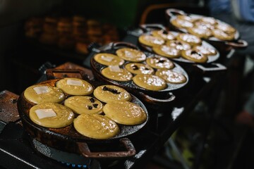 Coconut milk, flour, eggs, and potatoes are fried in a cake pan to produce traditional Indonesian snacks known as Kue Lumpur or Mud Cake