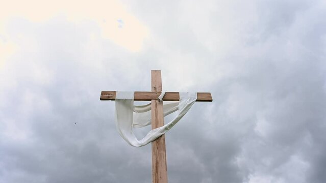 Jesus Christ crucifixion cross. Easter background, He is risen concept. Clouds in grey  sky at dusk. 