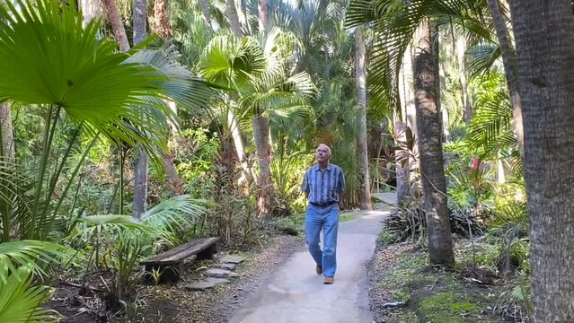 Elderly man walking through a botanical garden