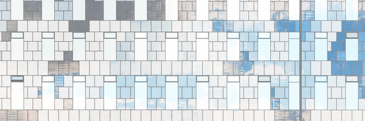 The facade of a modern high-rise building. Front view of many windows. Wall of various shades of gray. Wide panoramic urban background for design.