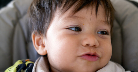 closeup of cute mixed race half asian baby boy smiling and laughing
