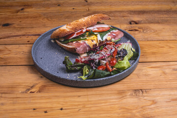 Emparedado de jamón acompañado de ensalada, queso, aderezo, vegetales y bebida cocktail 