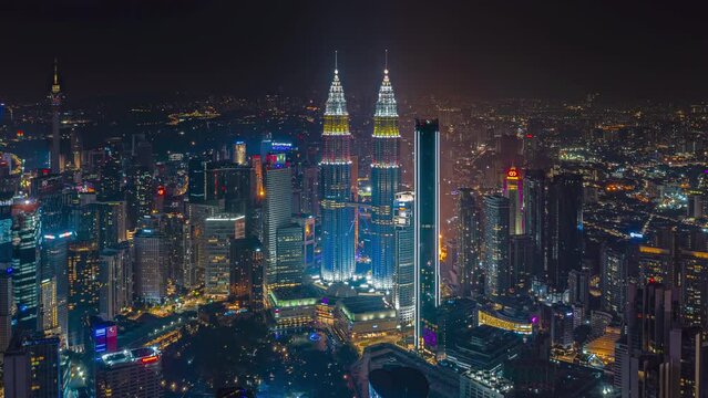 Aerial night view time lapse overlooking Kuala Lumpur skyline with busy city streets in Kuala Lumpur, Malaysia. Zoom out motion timelapse. Prores 4KUHD.