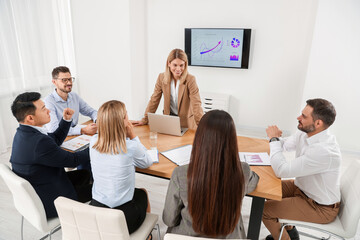 Naklejka na ściany i meble Businesswoman having meeting with her employees in office
