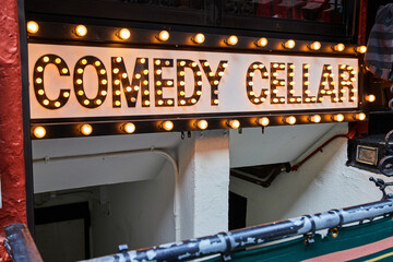 Comedy Cellar neon bulb lights sign going into basement in New York City