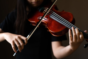 Teen playing violin in formal wear